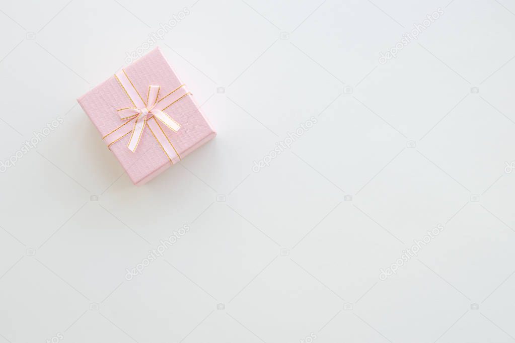 Pink gift or present box on table from above. Pastel color. Greeting card. Flat lay style. Copy space background
