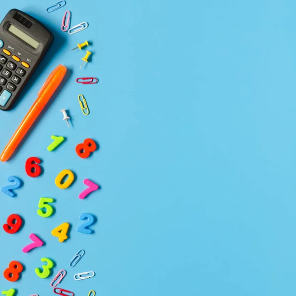 Hesap makinesi, kalem, mavi arka plan üzerinde renkli numaraları. Kopyalama alanı kompozisyon
