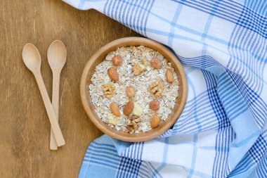 Kase müsli, iki kaşık ve ahşap masa havluda. Sağlıklı gıda. Temiz yemek. Genel gider gıda çekim.