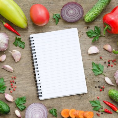 Çerçeve sebze: salatalık, domates, biber, soğan, sarımsak, maydanoz, havuç ve defter. Sağlıklı gıda, Vegan veya hasat kavramı kopya alanı kompozisyon