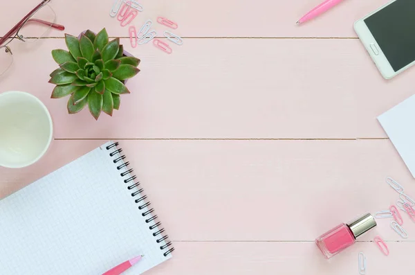 Kadınsı Resepsiyon çalışma alanıyla etli, Gözlük, cup kahve ve defter üzerinde pembe bir arka plan için. Düz yatıyordu, en iyi görünümü office tablo Resepsiyon çerçevesi.
