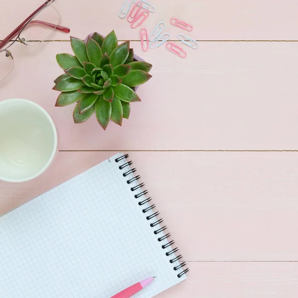 Kadınsı Resepsiyon çalışma alanıyla etli, Gözlük, cup kahve ve defter üzerinde pembe bir arka plan için. Düz yatıyordu, en iyi görünümü office tablo Resepsiyon çerçevesi.