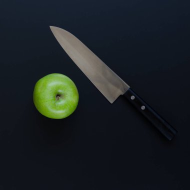 Yeşil elma ve siyah arka plan üzerinde bıçak. Havai çekim