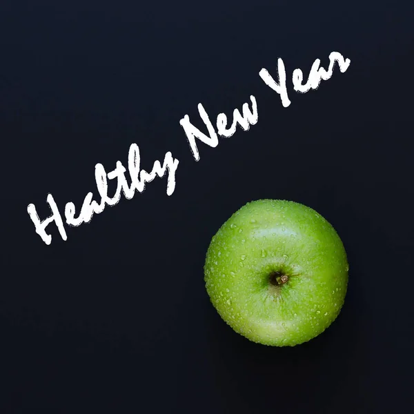 Green apple on black background. Healthy New Year concept. Overhead shots. Copy space composition