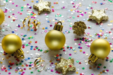 Noel dekorasyonu. Altın Noel oyuncaklar ve beton zemin üzerine renkli yıldız. Noel arka plan.