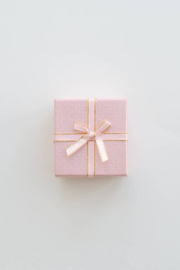 Bej renkli arka plan üzerinde pembe hediye kutusu. Pastel renk. Kutlama kavramı. Düz yatıyordu tarzı. Alan arka plan kopyalama