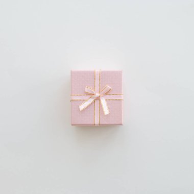Bej renkli arka plan üzerinde pembe hediye kutusu. Pastel renk. Kutlama kavramı. Düz yatıyordu tarzı. Alan arka plan kopyalama