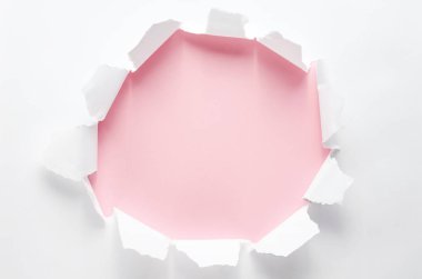 Pembe arka plan üzerinde beyaz kağıt kağıt delik.