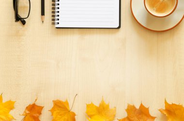 Dizüstü bilgisayar, kalem, gözlük ve kahve fincanı ile masaüstü.