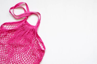 Beyaz ahşap arka planda pembe ağlı alışveriş çantası.