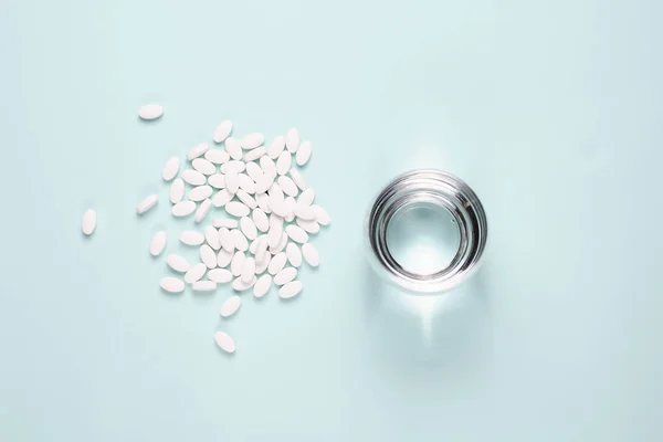 Beyaz hap mavi arka plan üzerine açık su ile.