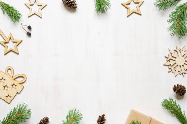 Noel ağacı dalları, koniler ve tahta Noel aksesuarları beyaz ahşap bir arka planda. Çerçeve. Boşluk bileşimini kopyala