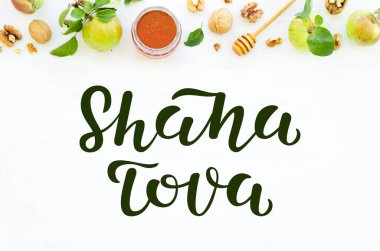 Tatlım, beyaz ahşap arka planda elmalar ve cevizler. Yemeklerin üstünden. Shana Tova harfleri