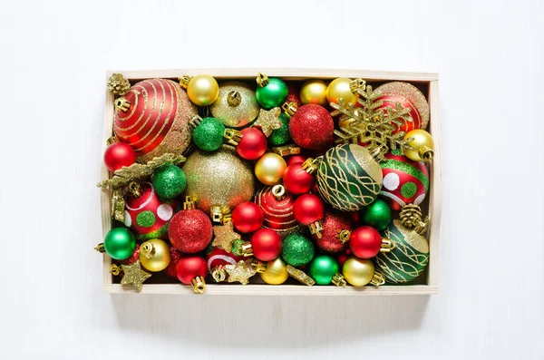 Beyaz ahşap arka planda ahşap bir tepside Noel aksesuarları. Tepeden çekim.