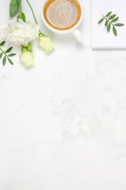 Bir fincan kahve, Eustoma, fıstıklı yeşillik, not defteri ve çimento kaplı kalem. Üst kattaki daire tepemizde duruyordu. Boşluk arkaplanı kopyala