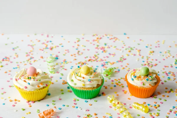 Τρία Πολύχρωμα Σπιτικά Cupcakes Λευκό Ξύλινο Φόντο Τρούφα Γιορτινή Ιδέα — Φωτογραφία Αρχείου