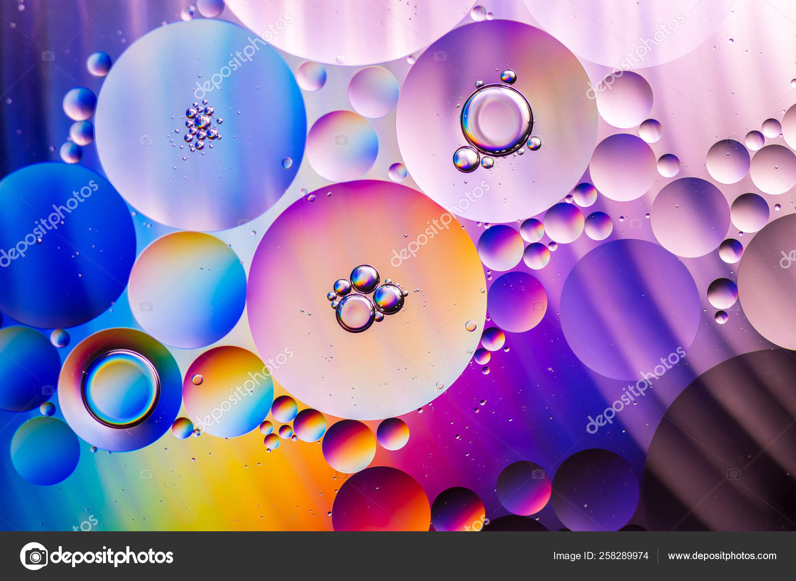 五颜六色的油滴在水中抽象背景五颜六色的泡泡油在水中 图库照片 C Chuchawan