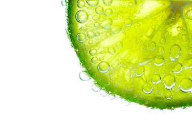 Beyaz arka planda izole yeşil taze kireç üzerinde su kabarcıkları, yakın çekim 