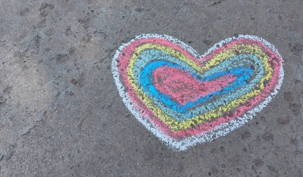 rainbow heart drawn with chalk on the asphalt. love confession. banner place for text, valentine children creativity, copy space, summer