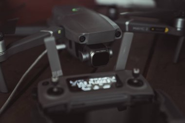 Eski ahşap masada bir uçuş kontrolörü ve dizüstü bilgisayar ile Drone quadcopter.
