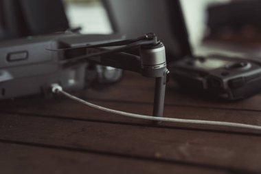 Eski ahşap masada bir uçuş kontrolörü ve dizüstü bilgisayar ile Drone quadcopter.