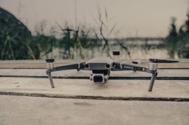 Eski ahşap masada bir uçuş kontrolörü ve dizüstü bilgisayar ile Drone quadcopter.