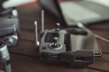 Eski ahşap masada bir uçuş kontrolörü ve dizüstü bilgisayar ile Drone quadcopter.