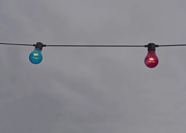 Röd Och Blå Färg Glödlampa Sträng Mot Grå Himmel Bakgrund — Stockfoto