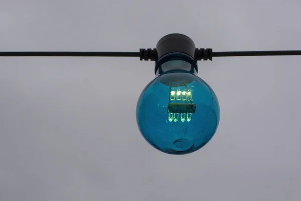 Blå Färg Glödlampa Sträng Mot Grå Himmel Bakgrund — Stockfoto