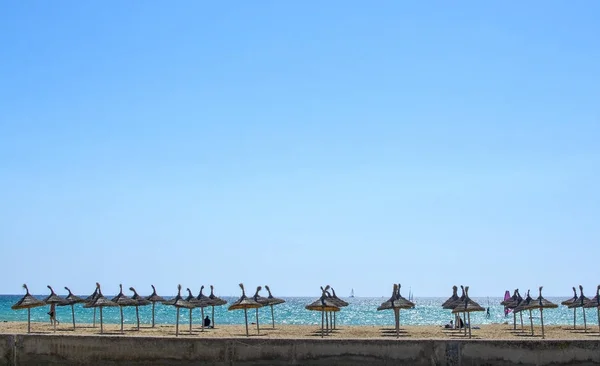 Praia de areia com guarda-sóis, vasto céu azul e kitesurfers — Fotografia de Stock