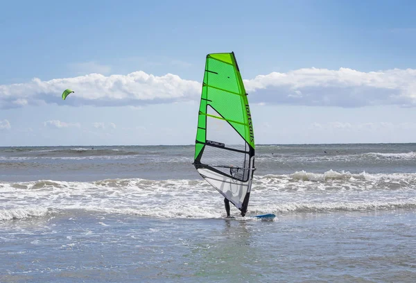 Surfers play in the green waves — Stock Photo, Image