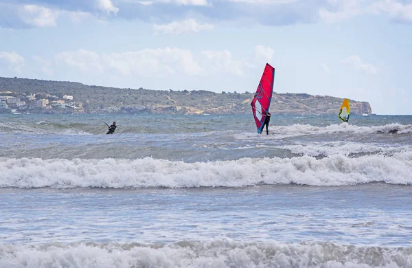 Windsurfer avec voile rouge joue dans les vagues vertes — Photo
