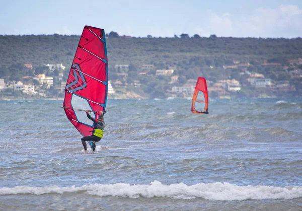 Windsurfer with red sail plays in the green waves — Stock Photo, Image