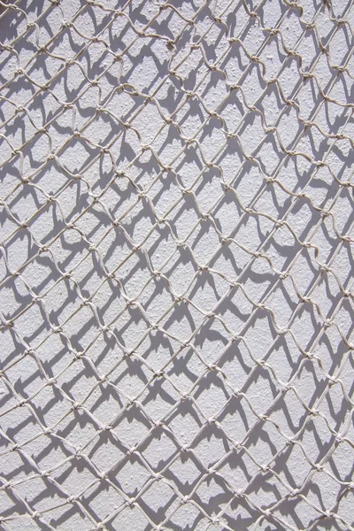 Filet de pêche blanc mur blanc — Photo