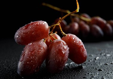 Meyvelerin üzerine su damlayan kırmızı sulu üzümler..