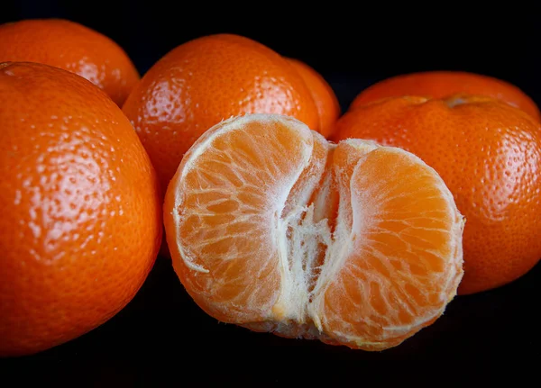 Yarı saflaştırılmış mandalina ve tam mandalina. siyah arkaplan.