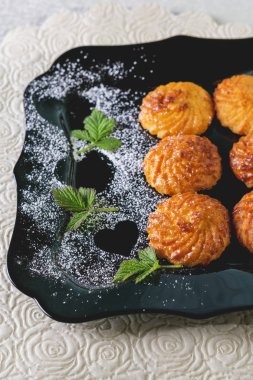 Toz şeker ile koyu bir plaka üzerinde çerezler.