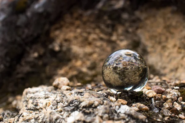 şeffaf bir cam top granit ve yosun ağaçlarıgökyüzünün bir yansıması vardır