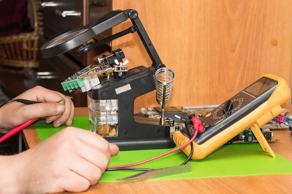 Master bir büyüteç ve multimetre kullanarak direnç, gerilim, kısa devre için kontrol ölçer