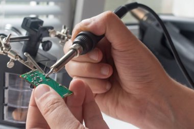 Bir lehim istasyonu ve diğer bileşenler kullanılarak lehimleme ile radyo panosunun onarımı