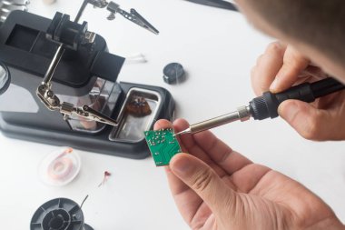 Bir lehim istasyonu ve diğer bileşenler kullanılarak lehimleme ile radyo panosunun onarımı