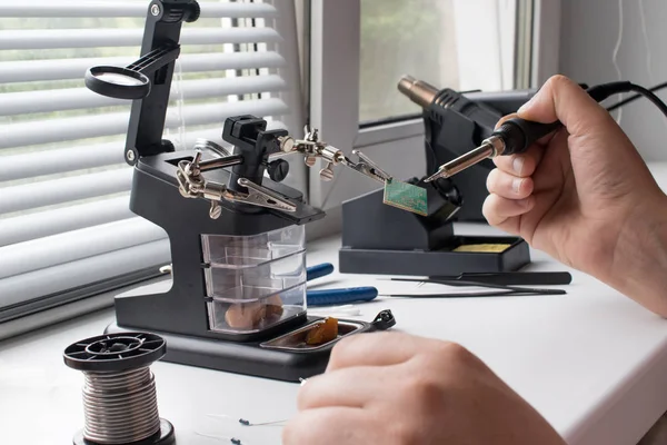 Bir lehim istasyonu ve diğer bileşenler kullanılarak lehimleme ile radyo panosunun onarımı