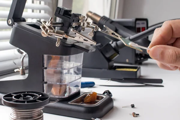 Bir lehim istasyonu ve diğer bileşenler kullanılarak lehimleme ile radyo panosunun onarımı