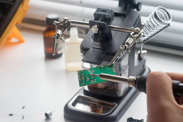 Bir lehim istasyonu ve diğer bileşenler kullanılarak lehimleme ile radyo panosunun onarımı