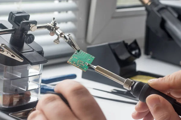 Bir lehim istasyonu ve diğer bileşenler kullanılarak lehimleme ile radyo panosunun onarımı