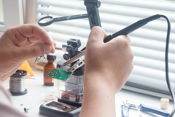 Bir lehim istasyonu ve diğer bileşenler kullanılarak lehimleme ile radyo panosunun onarımı