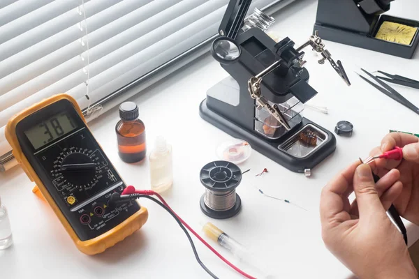 Bir lehim istasyonu ve diğer bileşenler kullanılarak lehimleme ile radyo panosunun onarımı