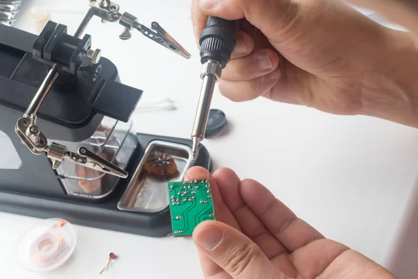 Bir lehim istasyonu ve diğer bileşenler kullanılarak lehimleme ile radyo panosunun onarımı