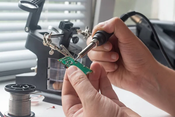 Bir lehim istasyonu ve diğer bileşenler kullanılarak lehimleme ile radyo panosunun onarımı