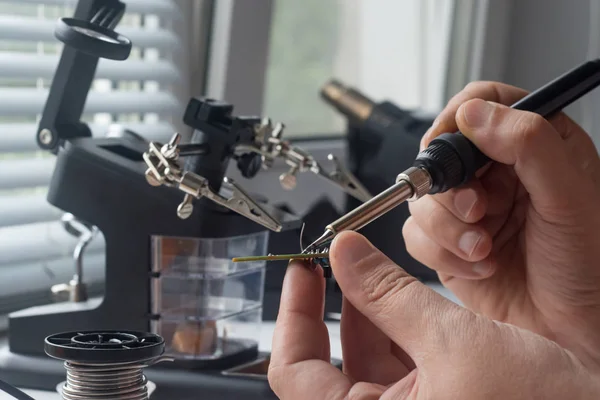 Bir lehim istasyonu ve diğer bileşenler kullanılarak lehimleme ile radyo panosunun onarımı